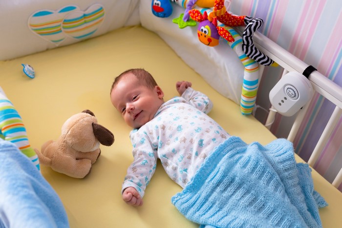 Infant in crib with toys