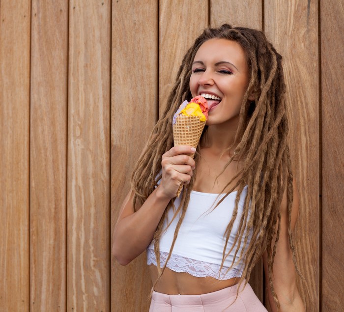 Woman with dreadlocks eating ice cream cone