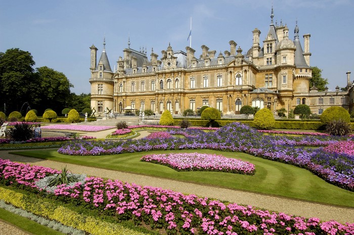 Waddesdon Manor gardens with colorful flowers and a large building