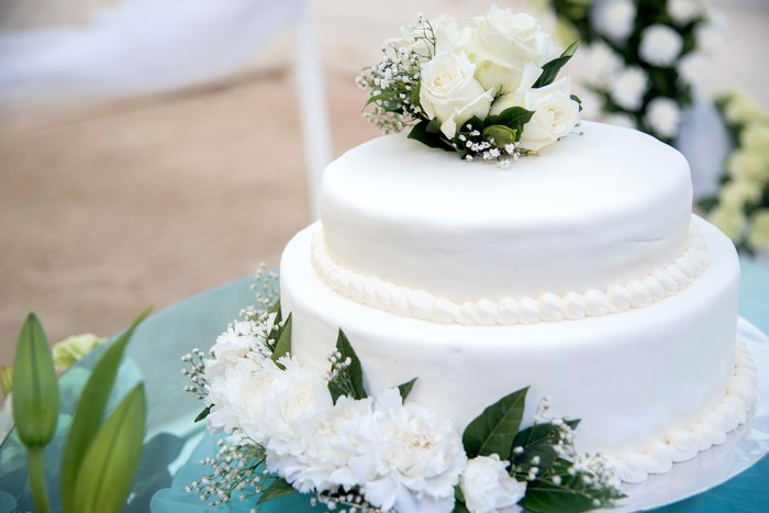 White two-tier wedding cake with roses