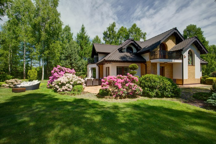 House with blooming rhododendrons and manicured lawn