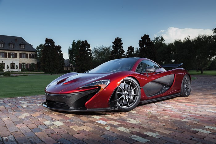 Red McLaren P1 parked on brick driveway