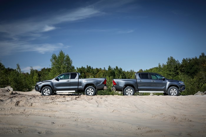 Two Grey Toyota Hilux Trucks on Sand