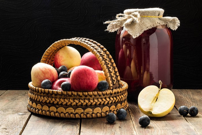 Basket of Apples and Berries next to a Jar of Preserves