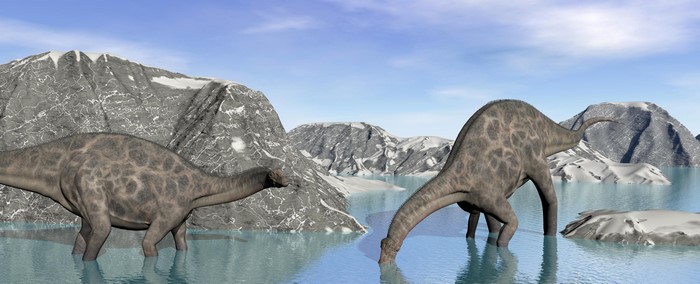 Two dinosaurs in a watery landscape with mountains