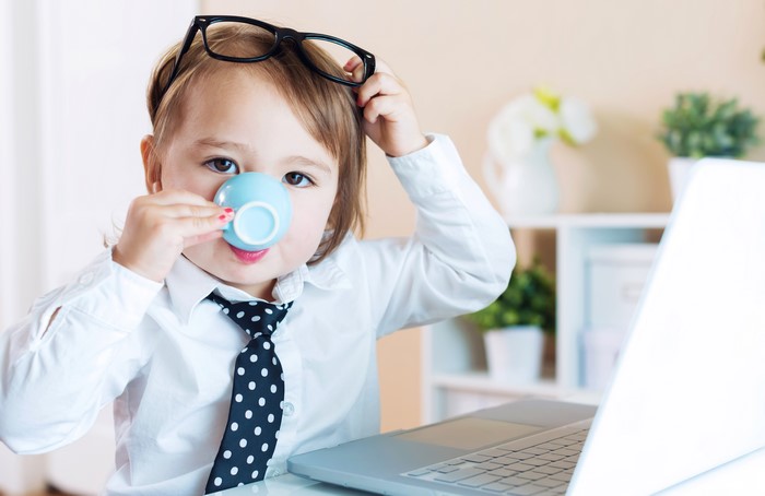Child in Glasses and Necktie Drinking from Cup