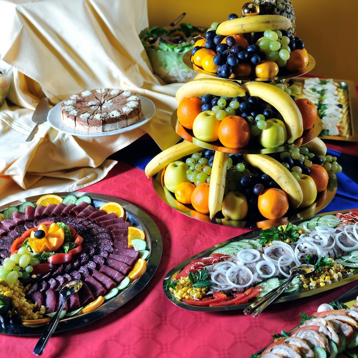 Buffet with cake, fruit, meat, and salad platters