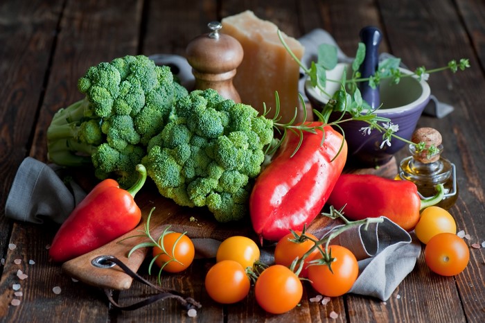 Broccoli, Bell Peppers, Tomatoes, and Cheese on a Wooden Table