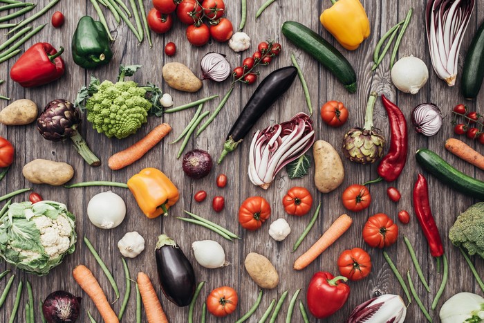 Assortment of fresh vegetables and fruits on a wooden table