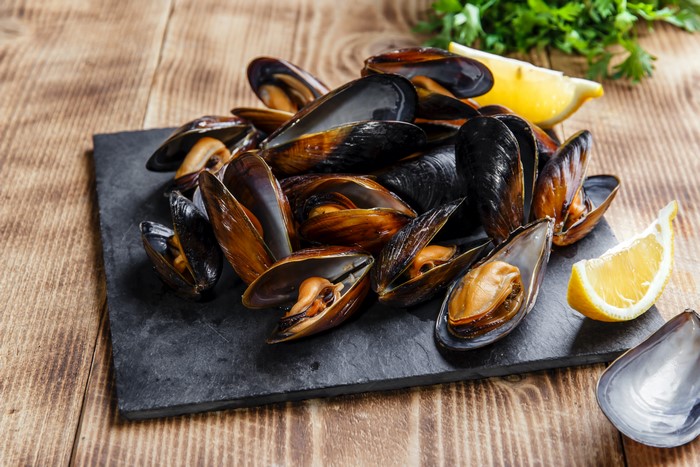 Cooked Mussels on a Slate Plate with Lemon