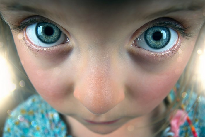 Close-up of a young girl's blue eyes and nose