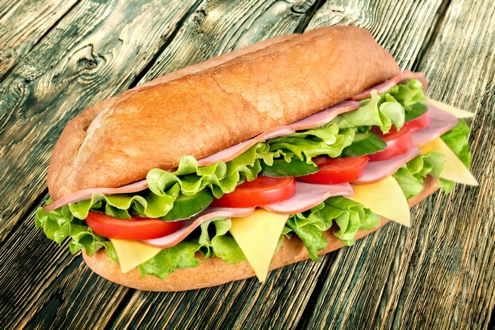Submarine sandwich with ham, cheese, lettuce, and tomato