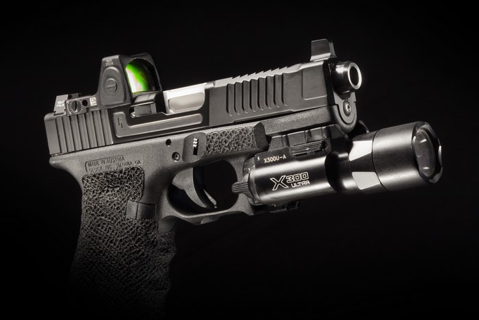 Glock pistol with red dot sight and tactical flashlight
