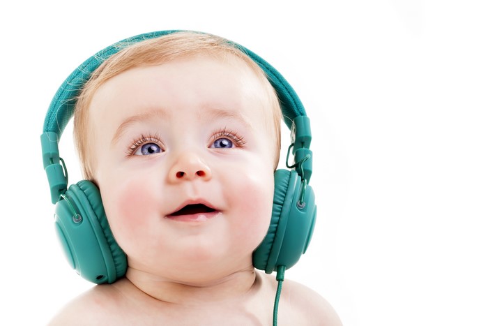 Baby wearing headphones on white background