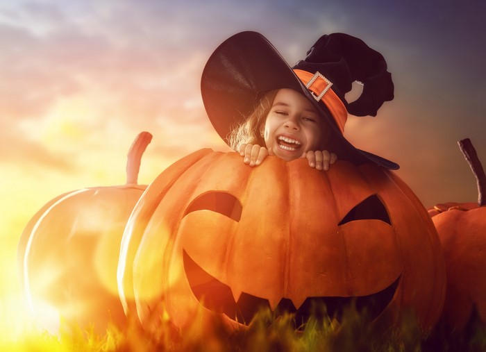 Girl in Witch Hat Peeking from Jack-o'-lantern