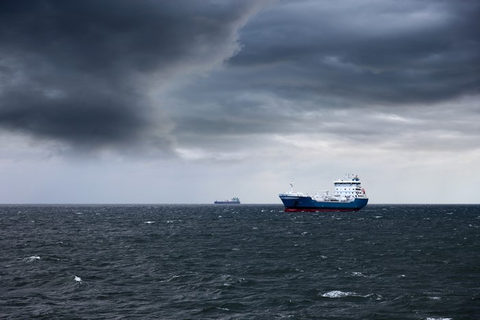 Two tanker ships on the sea under a stormy sky