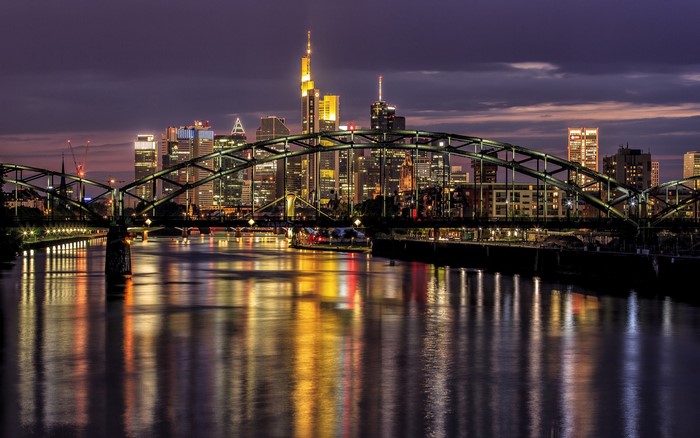 Frankfurt skyline and bridge over river at night