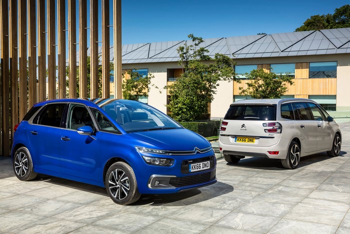 Two Citroen Grand C4 Picasso cars parked outside a modern building