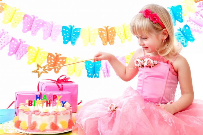 Girl in a pink dress with birthday cake and gifts