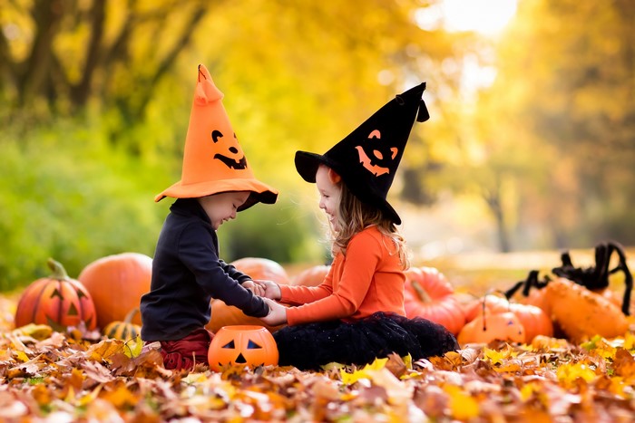 Children in Halloween costumes with pumpkins