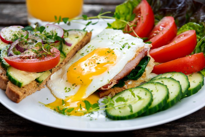 Fried egg with toast, vegetables, and orange juice