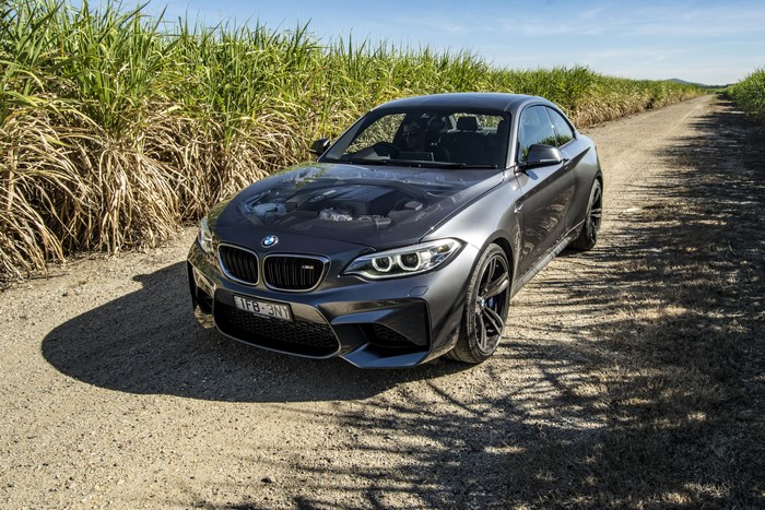 Grey 2016 BMW M2 Coupe on a dirt road