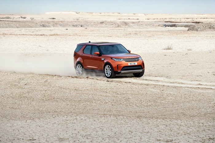 Orange Land Rover Discovery HSE driving in desert
