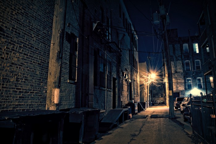 Alleyway at night with streetlights and buildings in Chicago
