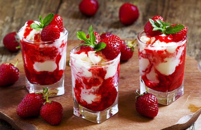 Three strawberry ice cream sundaes with mint