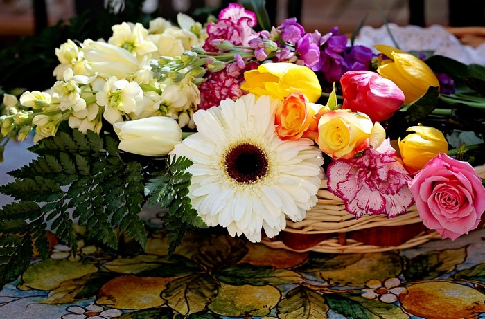 A colorful bouquet of Roses, Tulips, Gerberas, and Matthiola in a basket