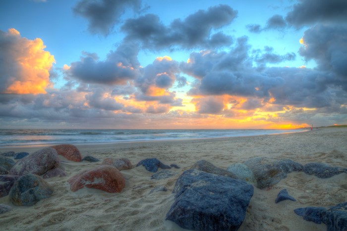 Sunset over the beach in Jylland, Denmark with stones