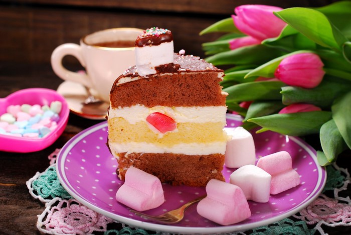 Slice of cake with tulips and candy