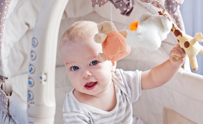 Baby playing with crib mobile