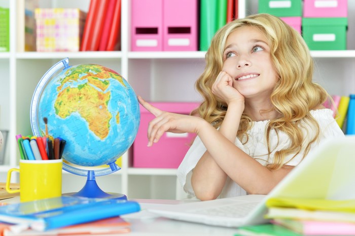 Little girl with blonde hair and a globe