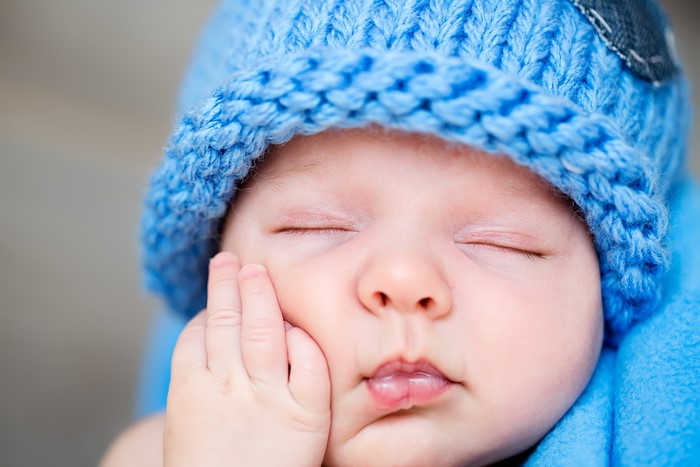 Baby wearing a blue knitted winter hat