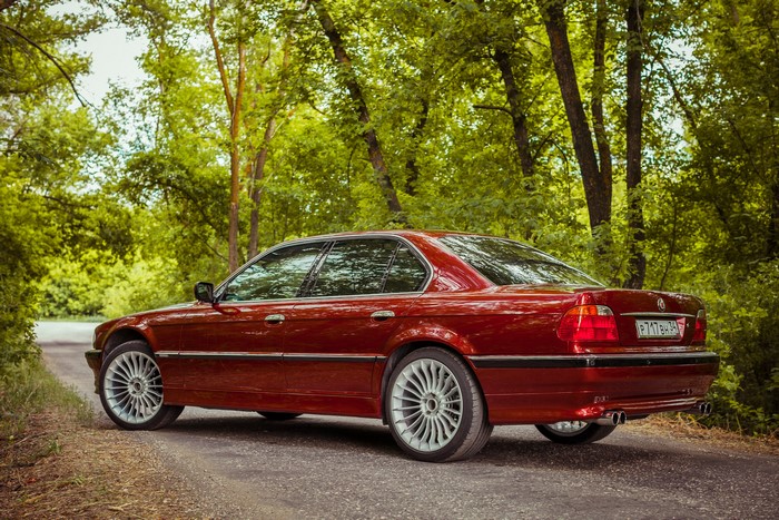 Red BMW E38 7 Series on a Forest Road