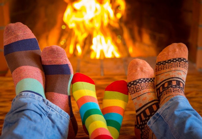 Feet in colorful socks by a fireplace