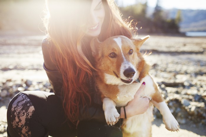 Woman hugging a Corgi dog