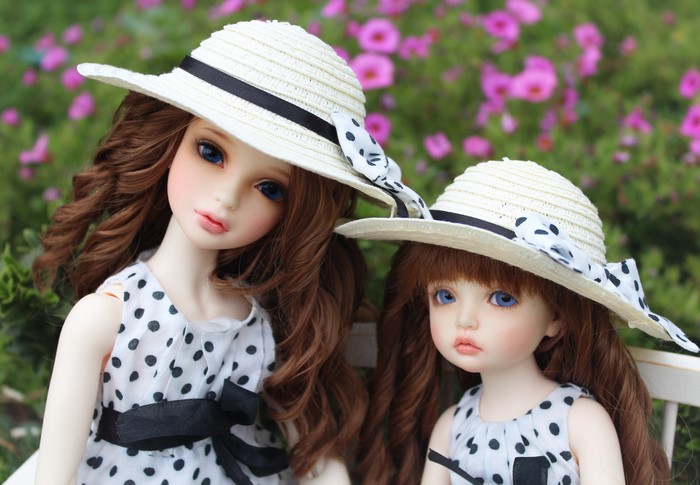 Two BJD dolls wearing straw hats and polka dot dresses