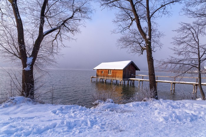 Wooden boathouse on a snowy lake in Bavaria, Germany