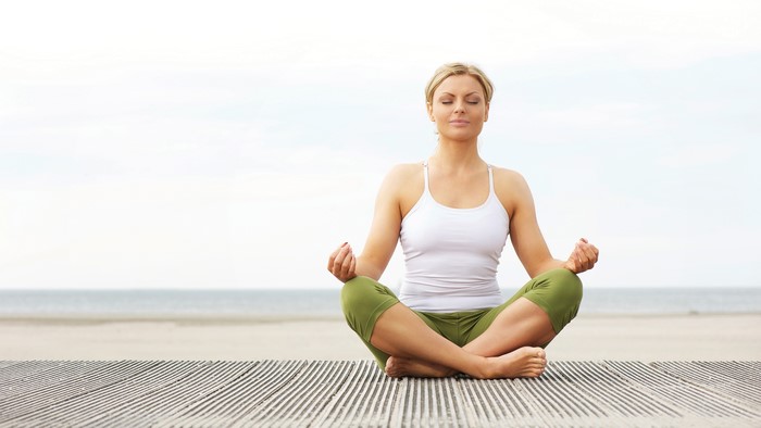Woman in Lotus Position on Beach