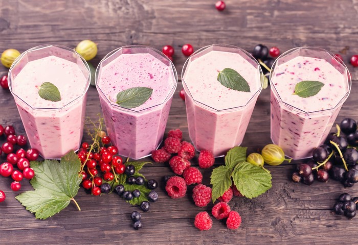 Four berry smoothies with fresh berries