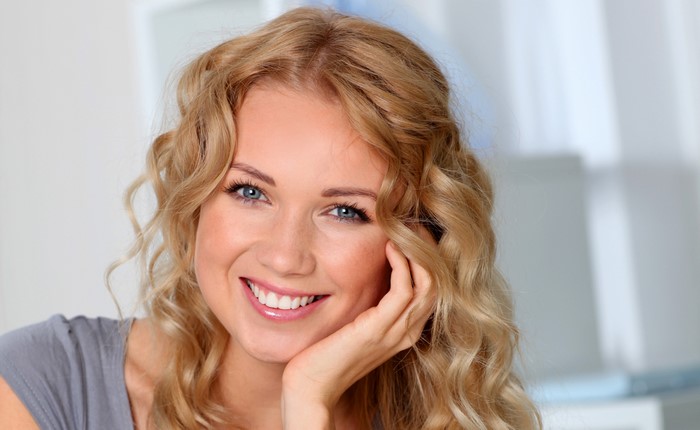 Woman with blonde curly hair smiling