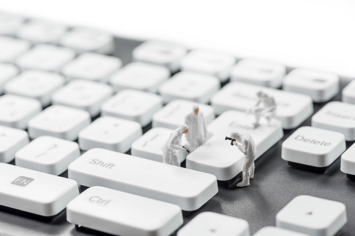 Miniature crime scene investigators on a keyboard