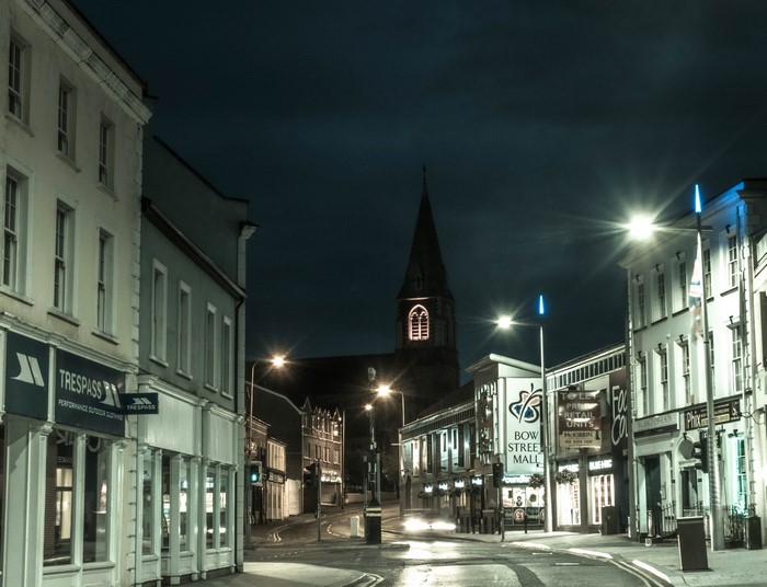 Night street scene in Lisburn, United Kingdom with shops and church