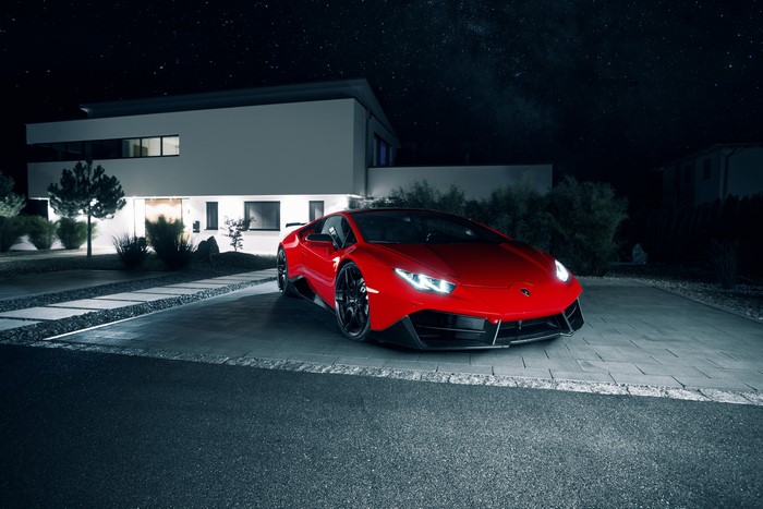 Red Lamborghini Huracan LP 580-2 parked at modern house at night