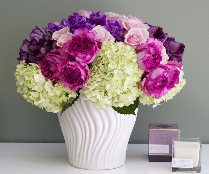Floral arrangement with roses, hydrangeas, and tulips in a white vase