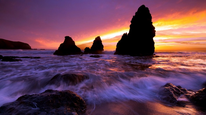 Jagged rocks in the ocean at sunset
