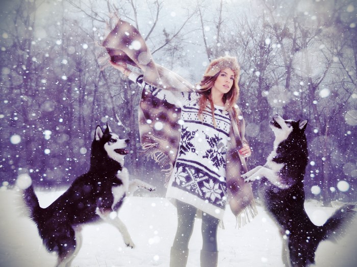 Woman with Huskies in Snowy Forest