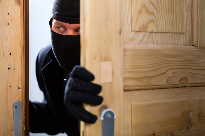 Thief peeking through a wooden door